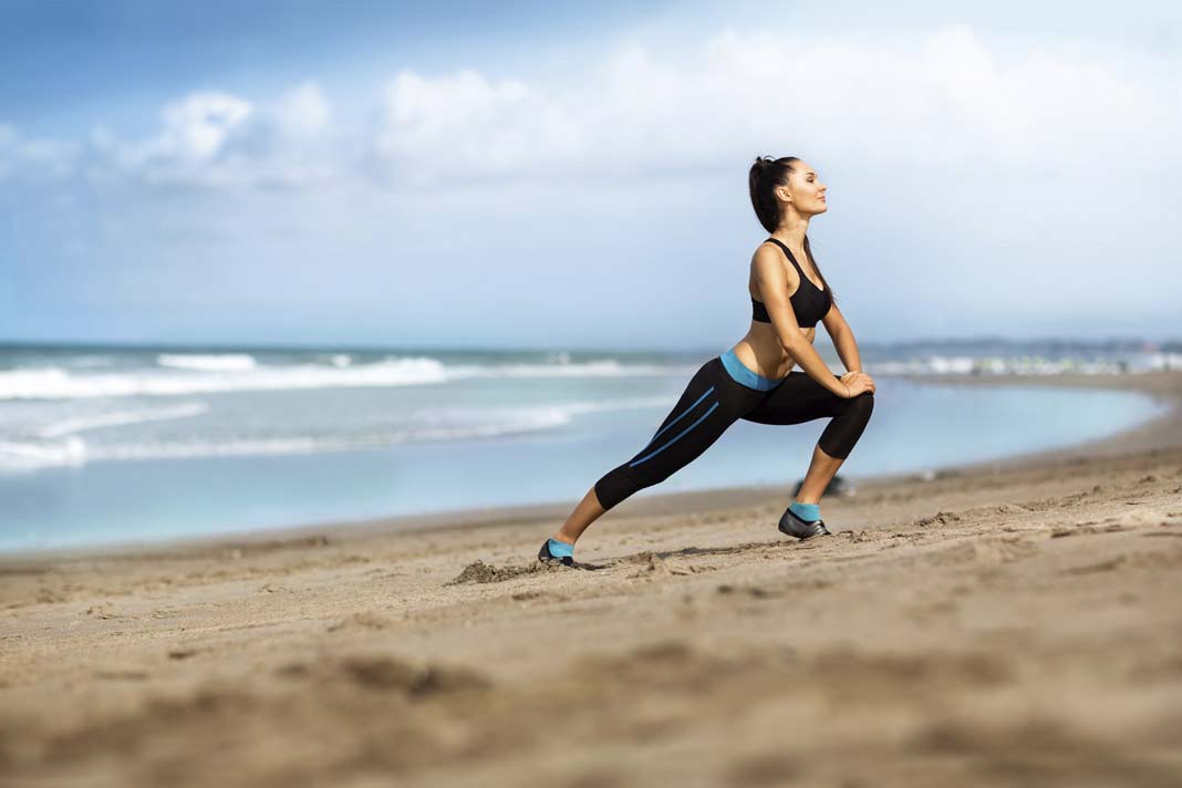 Attractive woman stretching on the beach